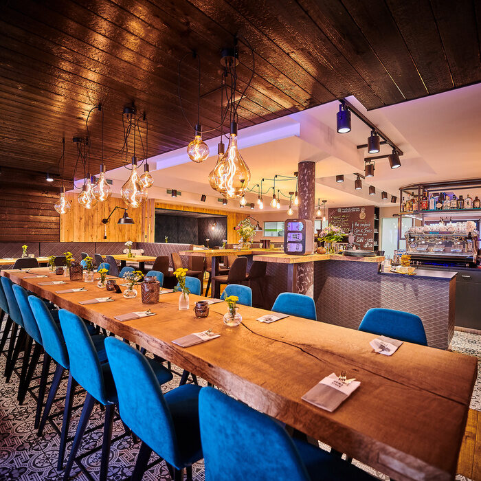 Ein langer Holztisch mit blauen Lichtakzenten