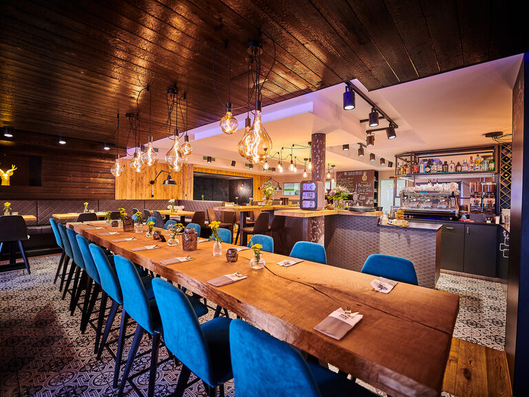 Ein langer Holztisch mit blauen Lichtakzenten